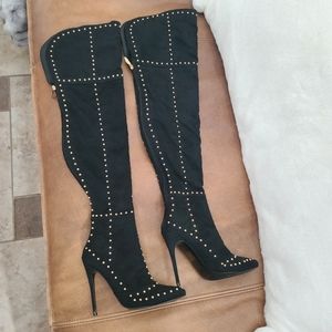Gold studed thigh high black boots.